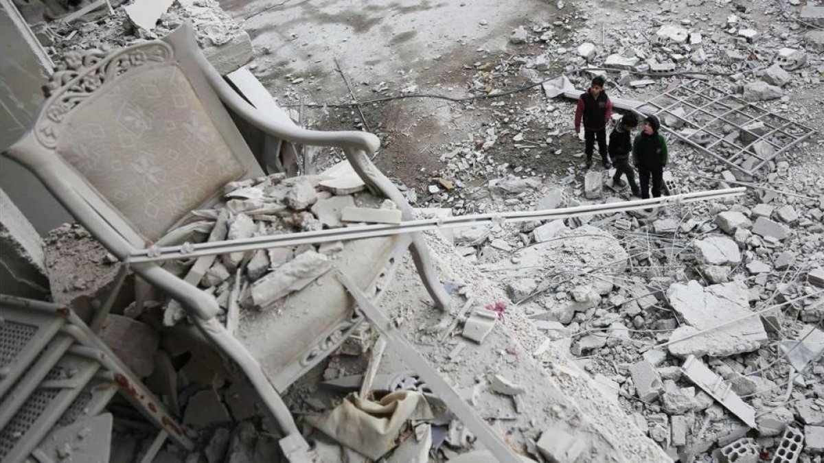 Niños frente a la destrucción en la ciudad de Arbin, en el este de Siria.-/ AFP / ABDULMONAM EASSA