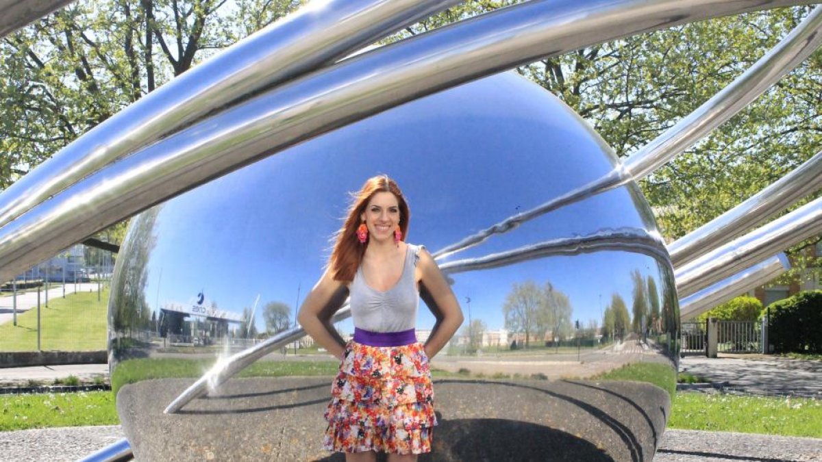 La Ingeniera Aeronáutica Laura Urbina, delante de CNES, junto a una estatua que representa un objeto en órbita alrededor de un cuerpo celeste.-EL MUNDO