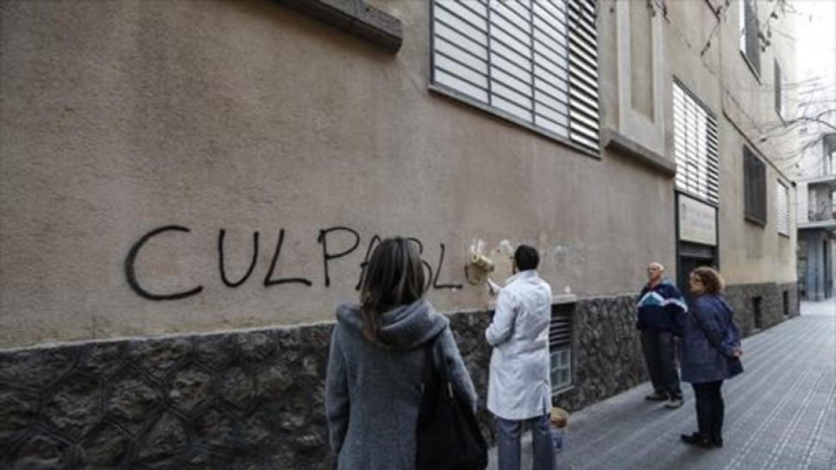 Un empleado tapa una pintada en los Maristas de Sants-Les Corts.-