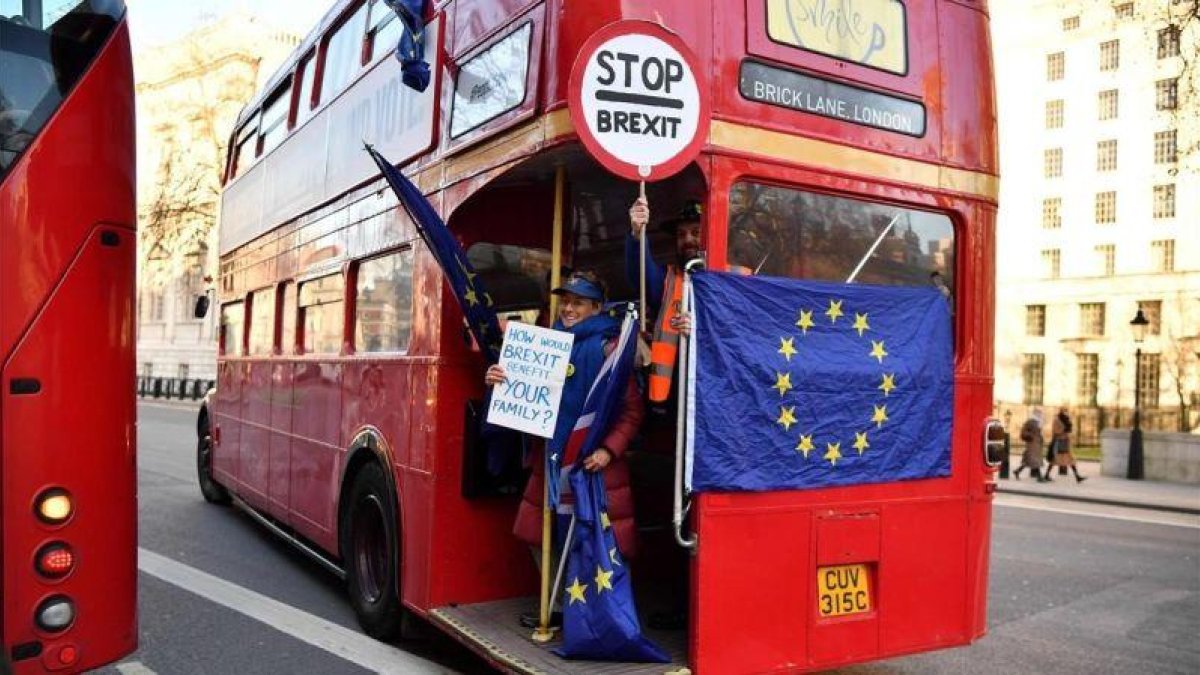 Un activista anti-brexit muestra una bandera de la UE en un autobús de Londres.-AFP / BEN STANSALL