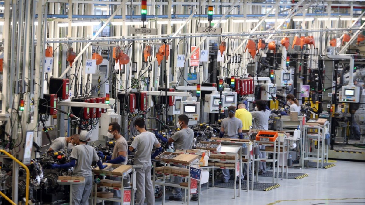 Trabajadores en una línea de trabajo de una industria automovilística