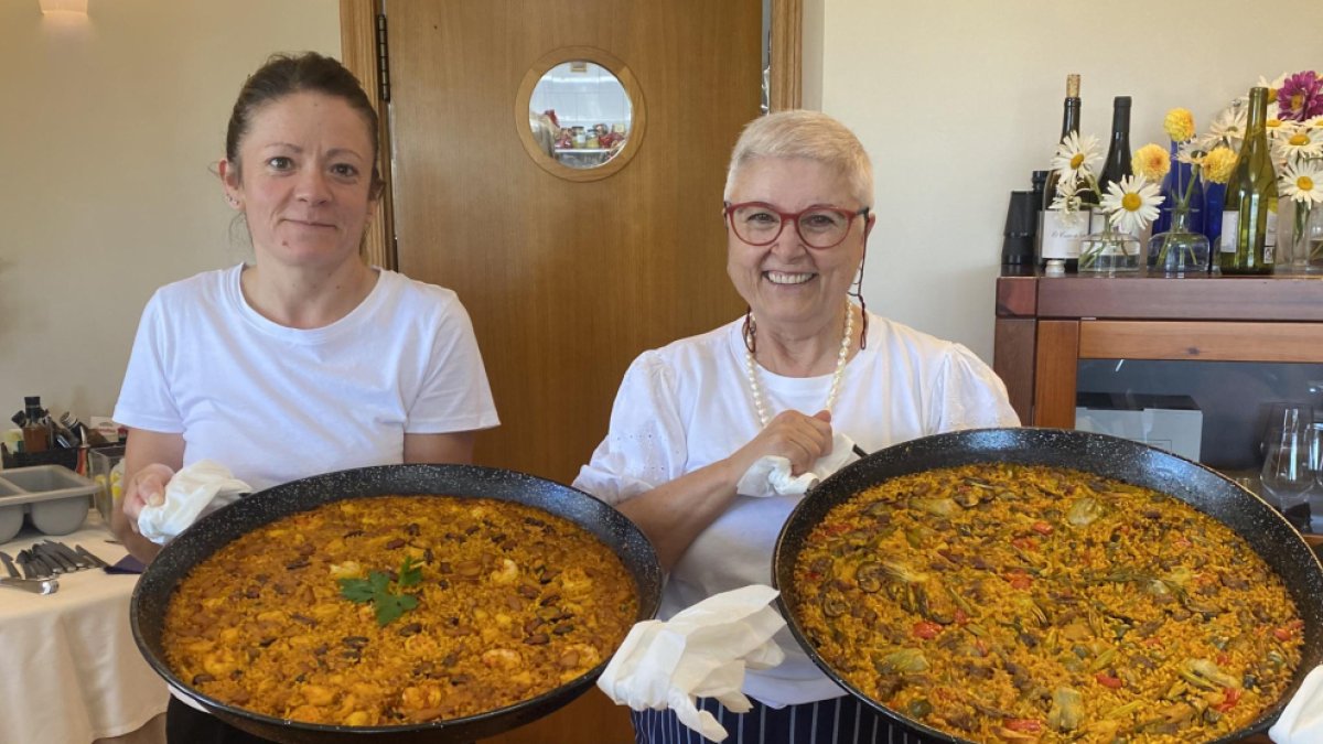 Eva Munera y Laura Fernández con dos paellas antes de servir a la mesa en el restaurante Villa Mencía en Corullón. /