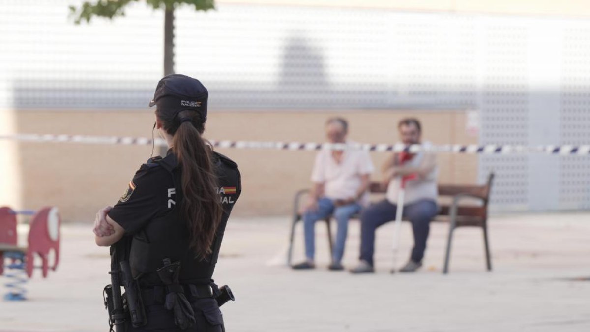 Una agente de la Policía Nacional en la calle Sisón donde se produjo el asesinato.