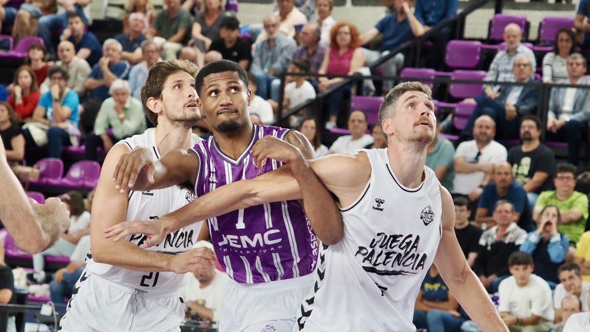 Wilson intenta zafarse del bloqueo del rebote de dos jugadores del Palencia Baloncesto.