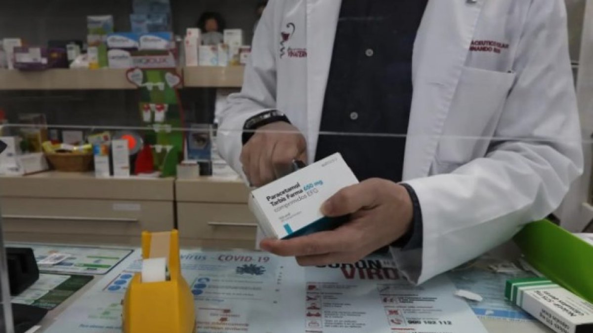 Un farmacéutico con una caja de paracetamol en su farmacia