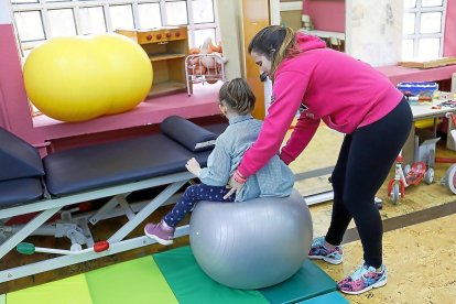 Una niña realiza ejercicios con el especialista en un colegio de Valladolid. / J.M.LOSTAU