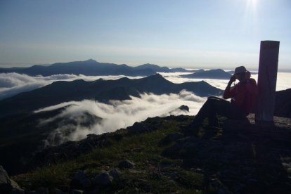 Un montañero fotografía el paisaje con el mar de nubes desde el vértice geodésico del Pico La Chana.-I.M.