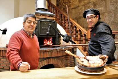 Luis Miguel Rodríguez y el maestro asador David Domínguez en el horno de leña de Casa Mariano.-J.L. CABRERO