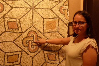 Laura Frías señala una tesela de un mosaico. Abajo, parte de la exposición y maqueta de la villa romana.-T.S.T.