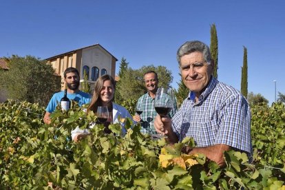 Moisés Gamazo en primer plano, seguido de Esther Pérez, Jesús Herranz y Víctor en el viñedo que está delante de la fachada de la bodega.-