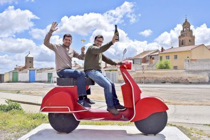 Miguel Ángel e Ignacio ya se han subido a la moto del vino, y lo hacen de forma simbólica sobre la escultura del artista local Juan Antonio Martín Carrión, en Pozaldez.-ARGICOMUNICACIÓN