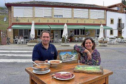 :Juanfran, con algunos platos del menú, y Lidia, con sus cuadros, en el exterior del restaurante.-ARGICOMUNICACIÓN