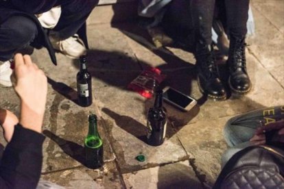 Unos jóvenes hacen 'botellón' en la vía pública.-ADRIANA DOMÍNGUEZ.