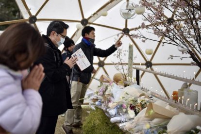 Varias personas rezan durante un evento celebrado en memoria de las víctimas del terremoto y posterior tsunami, el 11 de marzo del 2016.-FRANK ROBICHON (EFE)