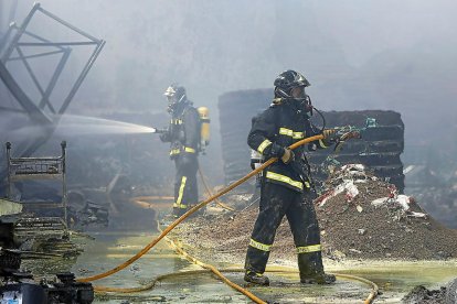 Bomberos de la Diputación este jueves, durante los trabajos de extinción del incendio en la nave de Cecoga.-J.M. LOSTAU