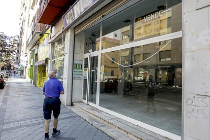 Un transeúnte lee el cartel de ‘se vende’ en el escaparate de un local vacío de la calle Labradores. J.M. LOSTAU