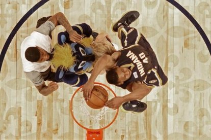 Glenn Robinson III salta por encima de Paul George (2,06), la mascota de los Pacers y una animadora del equipo para ganar el concurso de mates del All Star de Nueva Orleans.-EFE / GERALD HERBERT
