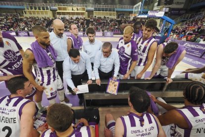 Paco García, pizarra en mano, da instrucciones a sus jugadores en un tiempo muerto. / PHOTOGENIC