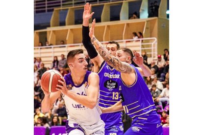 Alex Mazaira, en el poste bajo ante la defensa de dos jugadores de Ourense. RVB / ANA PUENTE