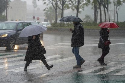 Peatones bajo la lluvia por el Puente de los Remedios en Sevilla a 22 de noviembre del 2019.-EUROPA PRESS