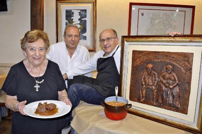 Martina Bachiller –junto a sus hijos, Susi y Carlos– con un guiso y el puchero que da nombre a las jornadas gastronómicas de febrero.-ARGICOMUNICACIÓN