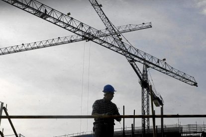 Un operario trabaja en la construcción de un bloque de pisos.