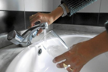 Una mujer echa agua del grifo en un vaso de cristal, en una imagen de archivo.