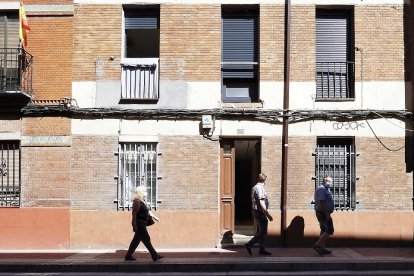 Vecinos pasan delante de uno de los portales de Padre Manjón donde hay familias aisladas.- PHOTOGENIC/M. Á. SANTOS