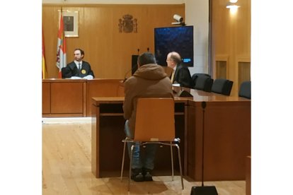 El presunto traficante, de espaldas, responde a las preguntas del fiscal durante el juicio. - EP.