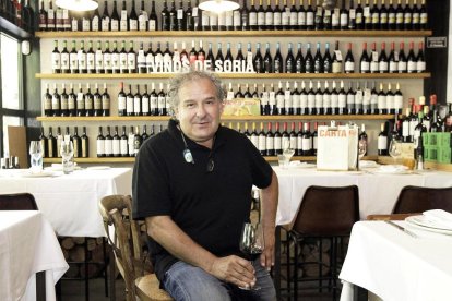 Roberto Aldea posa con una copita de vino ante una de las dos paredes del comedor repleta de referencias vinícolas vinculadas a la tierra que dentro del Kiosco.-LUIS ÁNGEL TEJEDOR