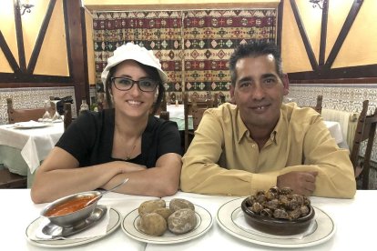 Miguel Ángel Gutiérrez y Carmen Castrillejo en el pequeño comedor del Mesón Canario con dos de los platos más representativos de su cocina: las papas arrugadas con mojo picón y los caracoles.-