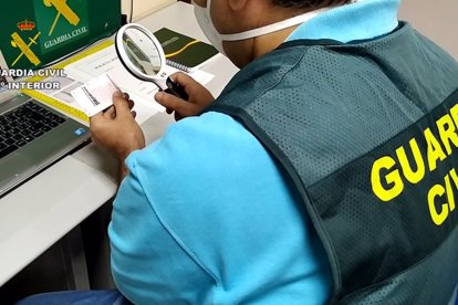 Un agente de la Guardia Civil inspecciona un carné de conducir. E.P.