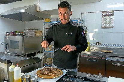 Ismael González se dispone a trocear un chuletón de avileña recién preparado.-DESTINO GREDOS