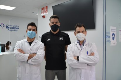 Los especialistas Javier Fernández y Eduardo Simón junto a Javier de Mesa, futbolista del Real Ávila y de la Selección Regional de Castilla y León, en el Centro Médico Angustias de Recoletas. EL MUNDO