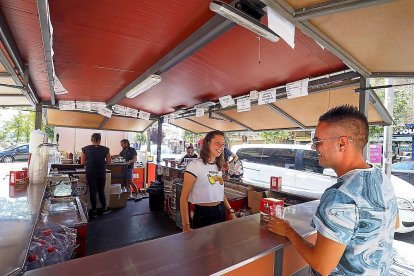 Un joven conversa con la encargada de una de las casetas festivas de la Feria de Día de Laguna, ayer.-MIGUEL ÁNGEL SANTOS