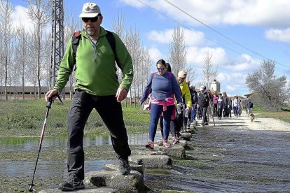 Un grupo de caminantes cruza uno de los arroyos de  a ruta.-L.P.