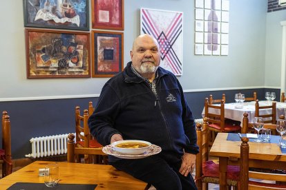 Carlos Calvo, en el comedor del restaurante y frente a las obras de sus hijos, Isabel y Alberto.