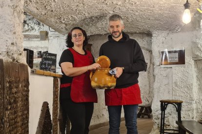 Susana García y Rubén Renedo, en el interior de la bodega, con un puchero de sopas de ajo.- LA POSADA