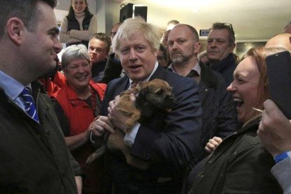 El primer ministro británico, Boris Johnson, sostiene un perro durante un encunetro con el recién elegido diputado del Partido Conservador en Sedgefield, Paul Howell, en el noreste de Inglaterra.-