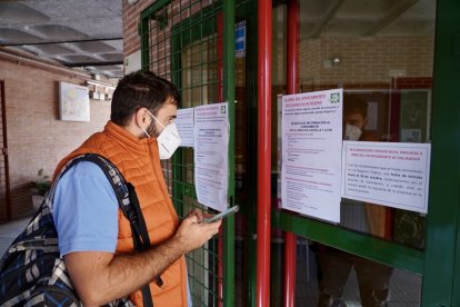 Un usuario consulta los números de teléfono proporcionados por el centro por el cierre de la Oficina de Municipal de Consumo de Valladolid.- ICAL