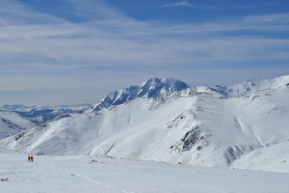 Dos montañeros ascienden hacia el pozo de Las Lomas, con la inconfundible silueta del Pico Espigüete (2.450 metros) de fondo. Debajo, primeros pasos de la ruta desde Cardaño de Arriba.-I. M.