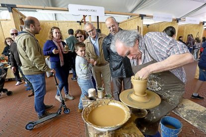 Pablo Hernández muestra sus técnicas a unos curiosos visitantes a la Feria de Artesanía de Medina del Campo.-J.M. LOSTAU