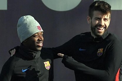 Piqué bromea con Dembélé en un entrenamiento.-LLUIS GENE