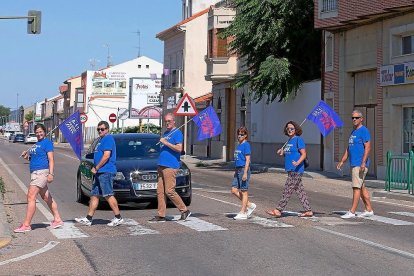 Miembros de la plataforma ‘A11 Pasos’ cruzan por un paso de peatones la travesía de la Nacional 122 con pancartas reivindicativas, ayer en Peñafiel.