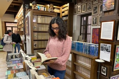 Una lectora ojea una volumen en la Librería Sandoval de Valladolid. | E. M.