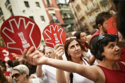 Unas mujeres muestran el símbolo de la campaña contra las agresiones sexistas en Sanfermines durante la manifestación ciudadana.-ÁLVARO BARRIENTOS (AP)