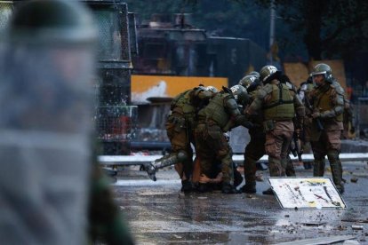 Fuerzas Especiales de Carabineros retienen a un manifestante este viernes en la Plaza Italia, rebautizada popularmente como “Plaza de la Dignidad”, durante una nueva jornada de movilizaciones y protestas, en Santiago (Chile).-EFE / ALBERTO VALDES