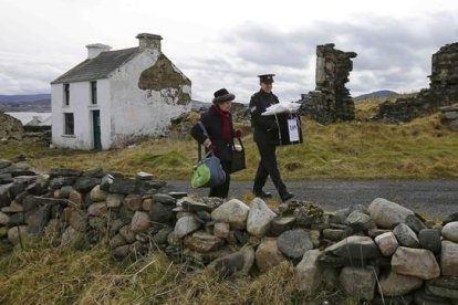 Dos oficiales se llevan la urna de la isla irlandesa de Inishbofin.-REUTERS / DARREN STAPLES