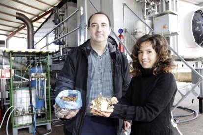 César Ciriano y Laura Hernández, junto  a la planta de torrefacción de madera que se emplea en Duruelo de la Sierra para realizar los ensayos.-LUIS ÁNGEL TEJEDOR