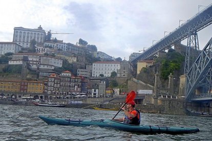 Paso de un turista en kayak por la ciudad portuguesa de  Oporto.-J.L.C.